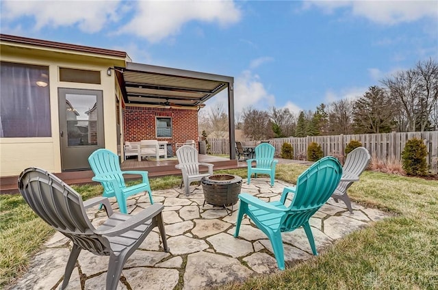 view of patio / terrace featuring an outdoor fire pit, fence, and a ceiling fan