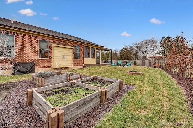 view of yard with an outdoor fire pit, a vegetable garden, and fence