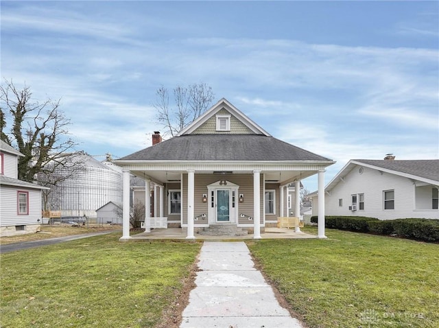 view of front of home featuring a shingled roof, a porch, and a front lawn