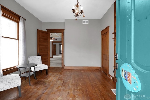 sitting room with plenty of natural light, wood finished floors, visible vents, and baseboards