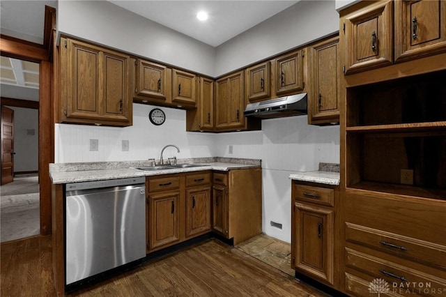 kitchen with dishwasher, dark wood-style flooring, light countertops, under cabinet range hood, and a sink