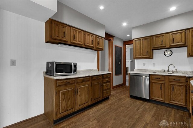 kitchen featuring dark wood-style floors, brown cabinets, stainless steel appliances, a sink, and recessed lighting