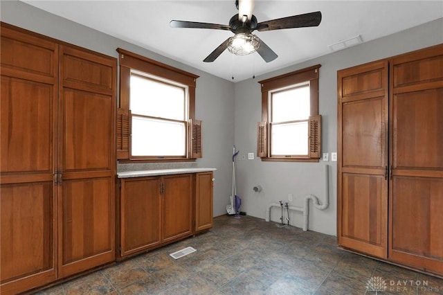 interior space with ceiling fan and visible vents