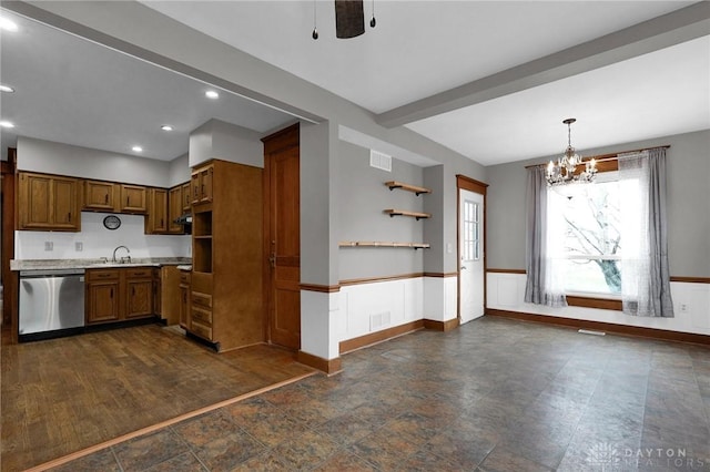 kitchen with a wainscoted wall, light countertops, visible vents, stainless steel dishwasher, and a sink