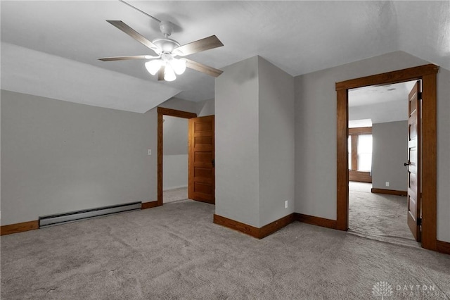 carpeted spare room featuring baseboards, a baseboard heating unit, vaulted ceiling, and a ceiling fan