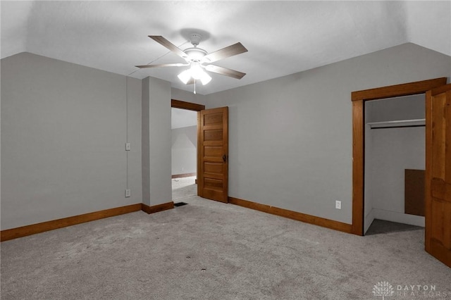 unfurnished bedroom featuring carpet floors, ceiling fan, baseboards, and vaulted ceiling