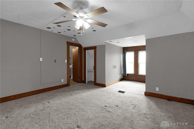 spare room with carpet floors, a ceiling fan, visible vents, and baseboards