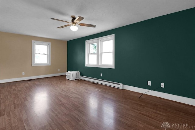 empty room featuring a ceiling fan, a baseboard radiator, baseboards, and wood finished floors