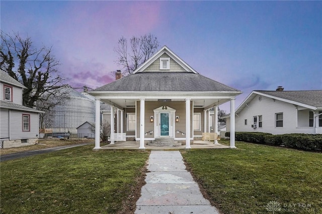 view of front of property with a porch and a front lawn