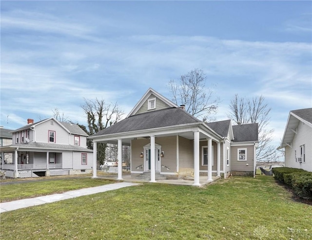 view of front of house with a porch, a front yard, and a shingled roof