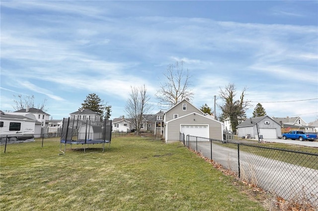 view of yard with a trampoline, a residential view, and fence