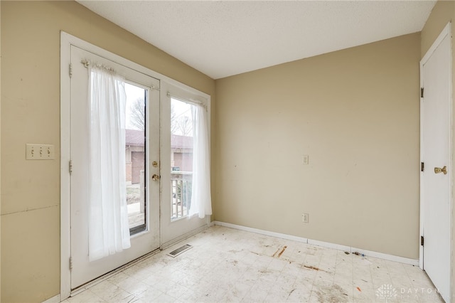 doorway to outside featuring baseboards, visible vents, and light floors