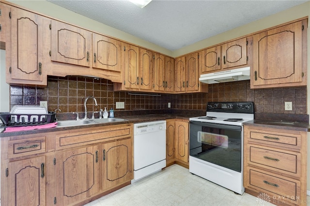 kitchen featuring range with electric stovetop, light floors, a sink, dishwasher, and under cabinet range hood