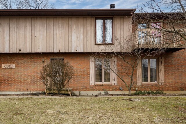 view of property exterior with a lawn and brick siding