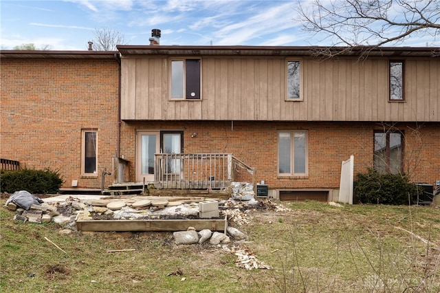 rear view of property featuring cooling unit and brick siding