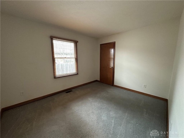 empty room with visible vents, baseboards, and light colored carpet