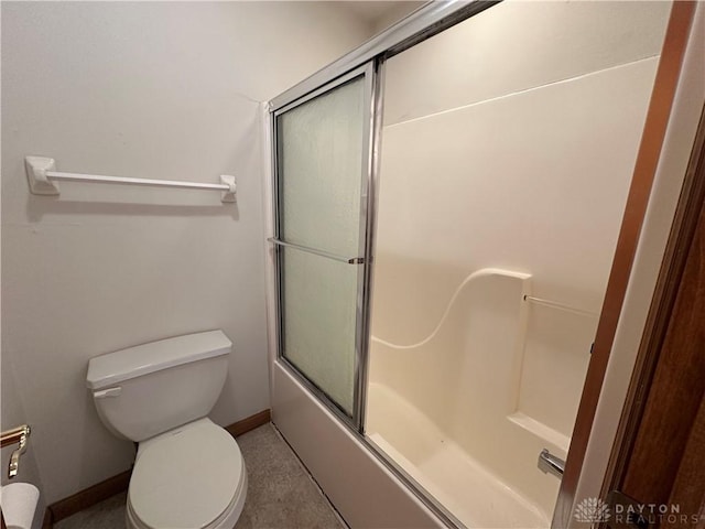 bathroom with enclosed tub / shower combo, toilet, and baseboards