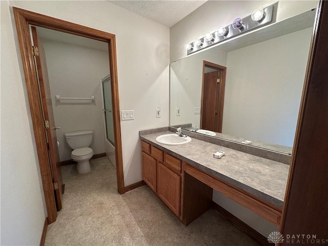 bathroom featuring baseboards, bath / shower combo with glass door, toilet, a textured ceiling, and vanity