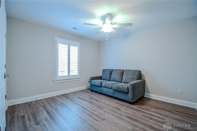 sitting room with a ceiling fan, wood finished floors, visible vents, and baseboards