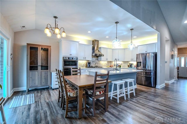 dining area featuring dark wood-style floors, visible vents, vaulted ceiling, and baseboards