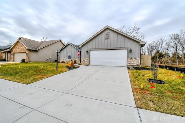 view of front of property with driveway, a garage, stone siding, a front lawn, and board and batten siding