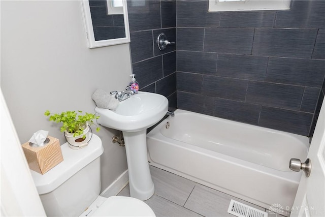 bathroom with visible vents, shower / tub combination, and toilet