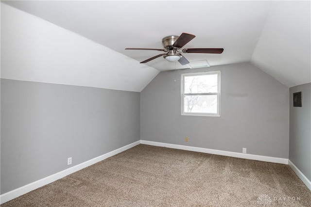 additional living space featuring lofted ceiling, carpet floors, a ceiling fan, visible vents, and baseboards