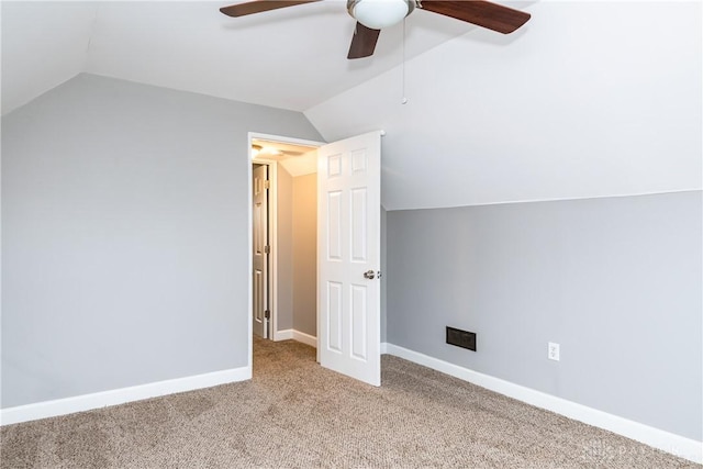 additional living space featuring visible vents, a ceiling fan, vaulted ceiling, baseboards, and carpet