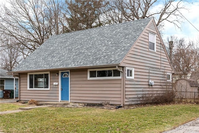 view of front facade featuring a front lawn and roof with shingles