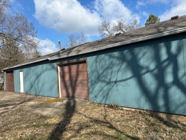 view of side of home with a garage and an outbuilding