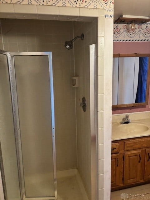 full bath with a stall shower and vanity