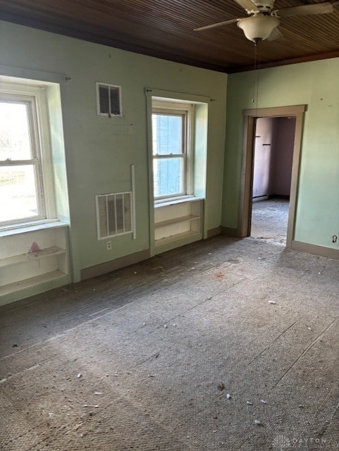 spare room featuring wood ceiling, visible vents, and a healthy amount of sunlight