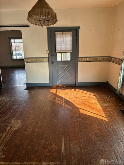 interior space with a barn door, baseboards, and hardwood / wood-style floors