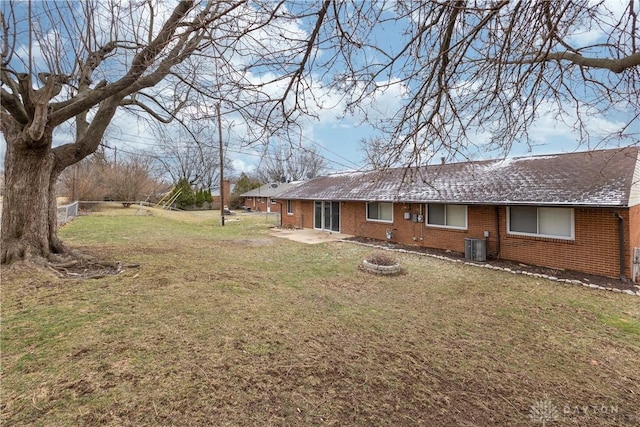 view of yard featuring a fire pit, fence, and central air condition unit