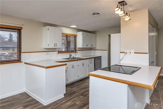 kitchen featuring dark wood-style flooring, visible vents, a sink, dishwasher, and black electric cooktop