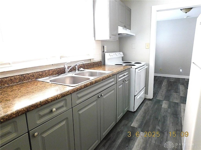 kitchen featuring under cabinet range hood, electric range, dark wood-style flooring, a sink, and baseboards