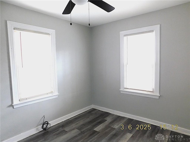 spare room with a healthy amount of sunlight, baseboards, dark wood finished floors, and a ceiling fan