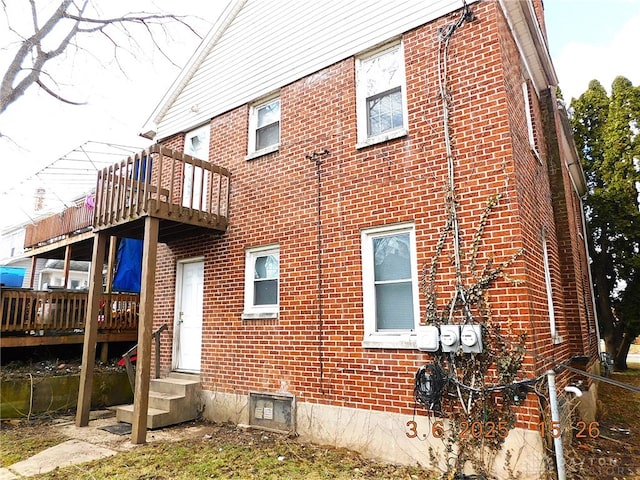 view of side of home featuring entry steps and brick siding