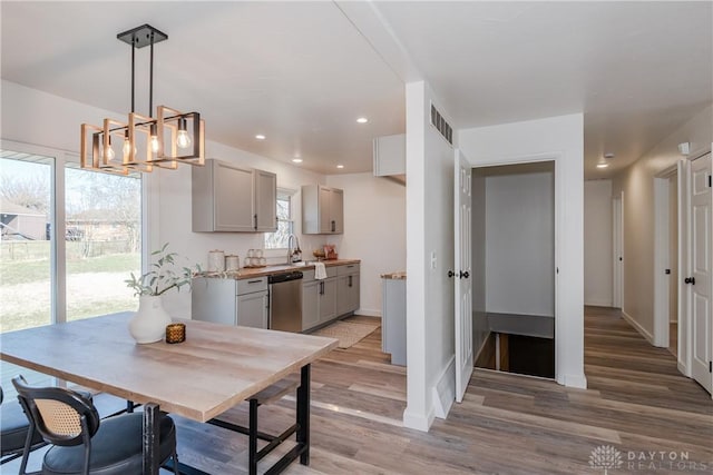 dining space featuring visible vents, baseboards, light wood-type flooring, recessed lighting, and a notable chandelier