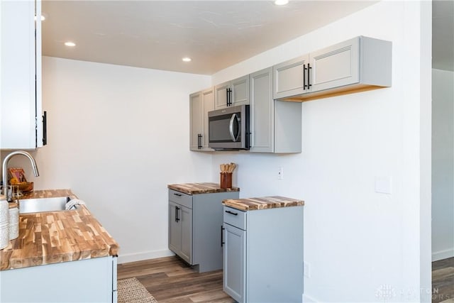 kitchen with recessed lighting, gray cabinets, a sink, light wood-style floors, and stainless steel microwave