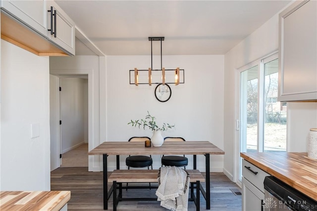 dining room featuring a notable chandelier, dark wood-style floors, and baseboards