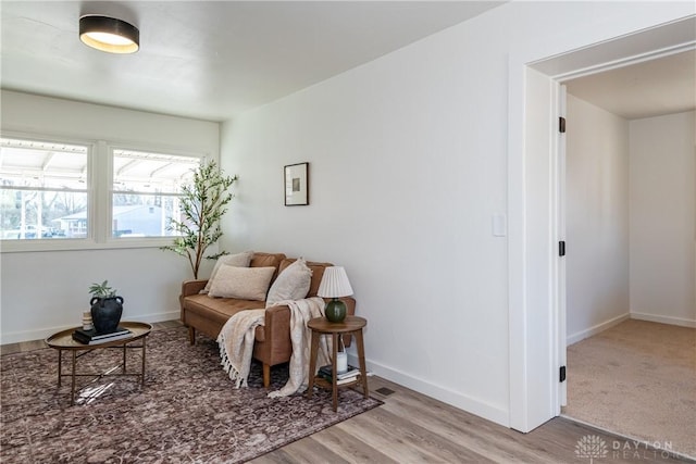 living area featuring baseboards and wood finished floors