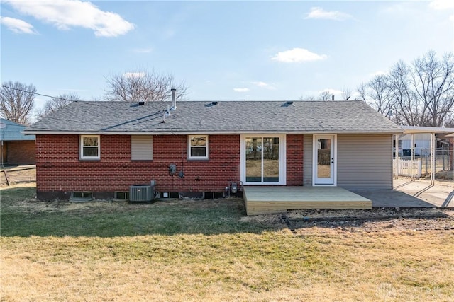 rear view of property with a yard, brick siding, roof with shingles, and cooling unit