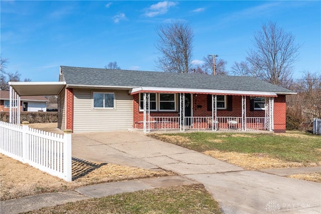 single story home featuring a carport, fence, covered porch, concrete driveway, and brick siding