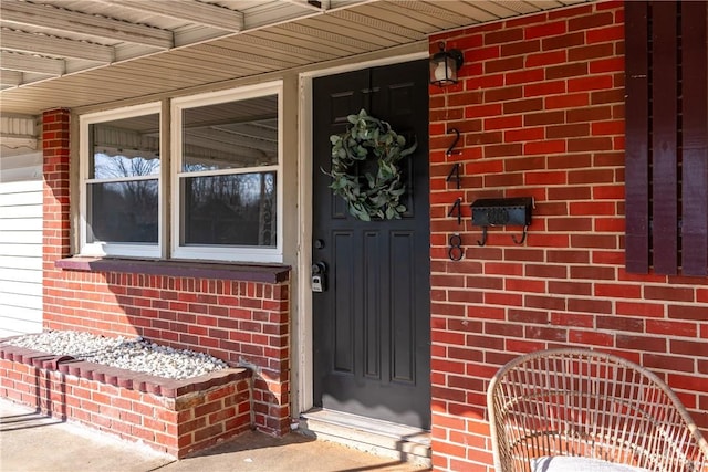 doorway to property with brick siding