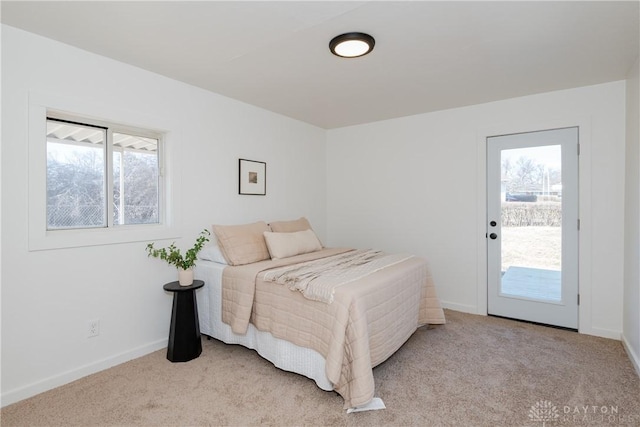 bedroom with baseboards, light carpet, and access to outside