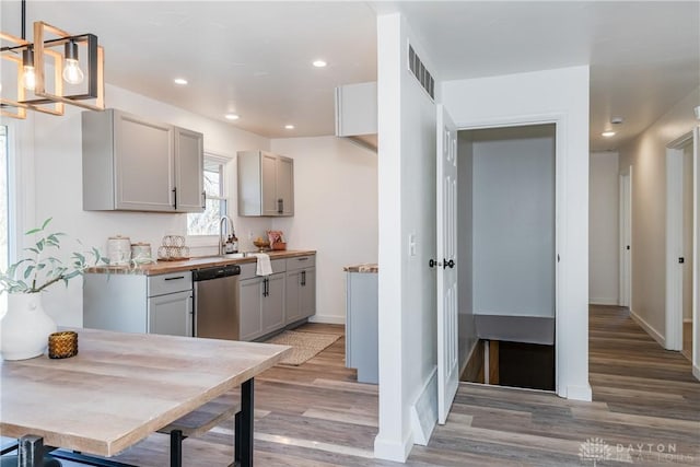 kitchen featuring visible vents, gray cabinets, dishwasher, and light wood-type flooring