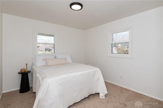 bedroom featuring light colored carpet and baseboards