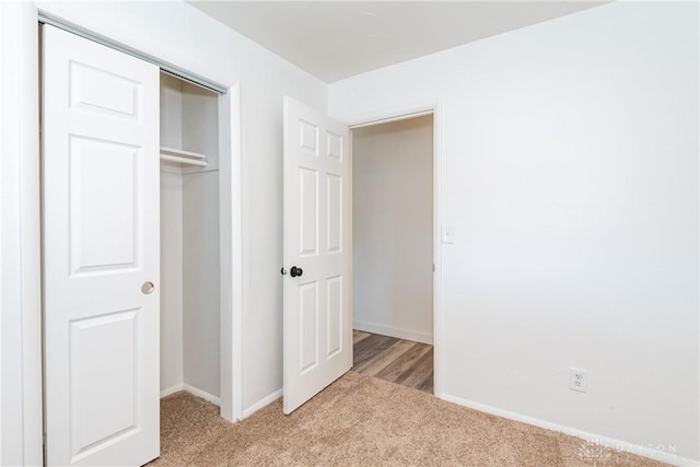 unfurnished bedroom featuring a closet, carpet floors, and baseboards