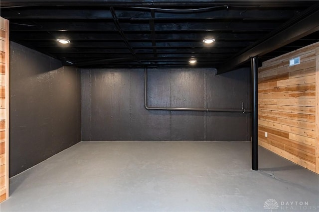 finished below grade area featuring wooden walls